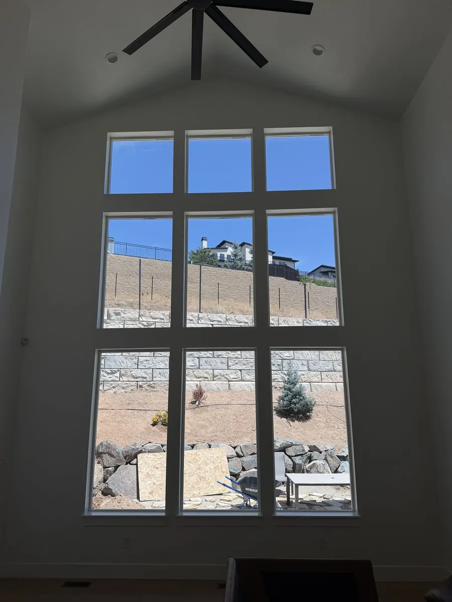 Tall residential windows filled with natural light after window film installation